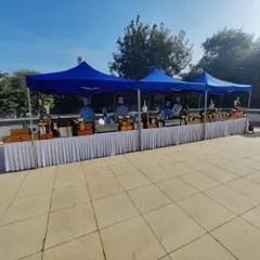 A wide view of the outdoor catering arrangement for Indigo Airlines. Multiple canopies and long buffet tables are set up to handle a large number of guests efficiently, demonstrating our capacity for large-scale corporate catering logistics.