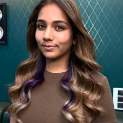 A little surprise of color. These peekaboo purple highlights add a playful, trendy twist to a classic wavy hairstyle, allowing you to show off your personality when you want to. It's the perfect way to experiment with color without a full commitment.