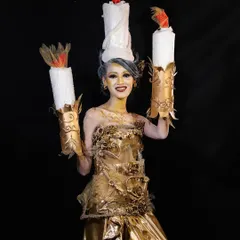 A smiling pose from the candle character, showing that even the most elaborate makeup can allow for expression and movement.