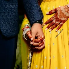 A beautiful moment between the couple, with the bride's intricate mehandi on full display. This is what makes the hard work worthwhile.