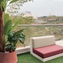 The master bedroom of Project 22 Days opens directly onto this inviting terrace. The use of artificial turf and plants ensures low maintenance while providing a lush, green escape with a stunning view.