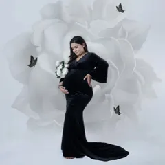 Simple, elegant, and powerful. In our studio, we create a peaceful space for you to just be. This black gown against the artistic floral backdrop is a classic look that focuses on the beautiful shape of your baby bump.