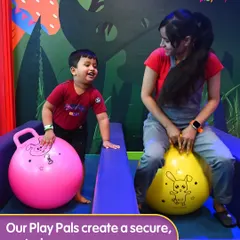 Our Play Pals create a secure, nurturing space for every child. Here, a staff member shares a moment of fun with a little one on the bouncy balls, showcasing the friendly and interactive supervision we provide.