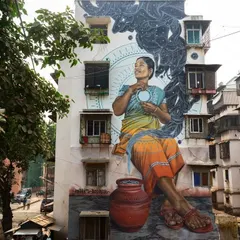 Artist Miles Toland's mural in Mahim East for the St+art festival. The artwork was designed to honor local culture, featuring a woman in a traditional sari who embodies the sunset, connecting the people to the cosmos.