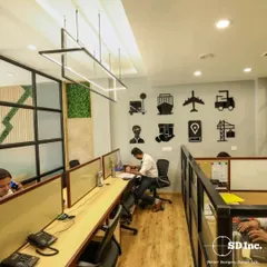 This collaborative workspace features custom wall art reflecting the company's logistics business. We used glass partitions and shared desks to create an open, energetic environment that fosters communication.