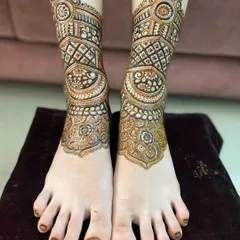 The leg mehendi design is now complete, with intricate bands of geometric and traditional patterns wrapping around the ankle.