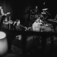 The full ensemble on stage. From left to right, you see the violin, tabla, my sitar, drums, guitar, and keyboard. This is the complete setup for a high-energy Indian fusion band performance.