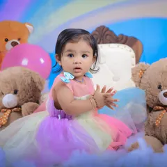 A playful, clapping moment during the rainbow-themed shoot. We create a fun atmosphere to bring out these adorable, natural reactions from children.