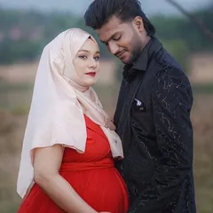 I believe every mom deserves to feel beautiful while honoring her style. This client looks radiant in a vibrant red gown paired with her hijab, and her partner's stylish black blazer completes their elegant outdoor maternity shoot.