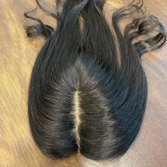 This is a top-down view of a 2x5 silk base topper, showing the incredibly realistic scalp effect. The hair appears to be growing directly from the base, ensuring no one will know your secret.