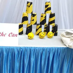 The 'Knock the Can' game is a simple but challenging classic. I provide the stacked cans and soft balls for players to test their aim and strength.