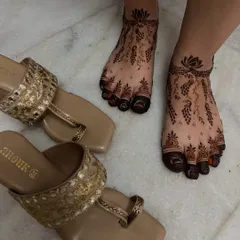 This photo shows how beautifully the peacock and vine foot design pairs with traditional footwear. The henna acts as a permanent, beautiful accessory.