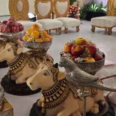 Another view of the decorated cow props, showing the detailed painting and the arrangement of apples and oranges.