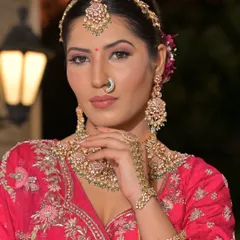 This close-up highlights a beautiful matha patti and a heavy choker necklace. This type of statement headpiece is perfect for framing the face and creating a memorable bridal look.