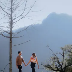 A beautiful walking shot against the backdrop of the Mussoorie hills. The hazy blue mountains create a dreamy and picturesque setting for this couple's portrait.