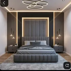 This master bedroom design creates a dramatic and luxurious feel with a floor-to-ceiling upholstered headboard, highlighted by recessed LED backlighting. The layered lighting scheme, including a modern chandelier and hanging bedside pendants, adds depth and sophistication to the contemporary grey palette.