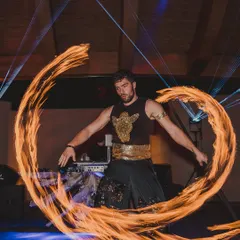 A fire dancer captivates the audience with his daring and mesmerizing performance. This is perfect for adding a 'wow' factor to an evening event.
