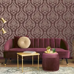 We celebrate classic grandeur with a contemporary lens. This opulent damask wallpaper, shown here in a rich burgundy, brings architectural depth and timeless sophistication to a modern living area.
