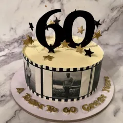 A journey through time for a 60th birthday. This cake features an edible photo filmstrip with pictures from the client's life, making it a truly personal and nostalgic centerpiece.