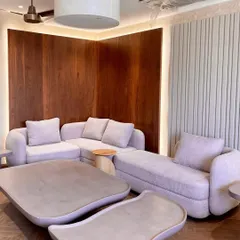 This living area showcases our organic and earthy design style. The custom sectional sofa in a textured lilac bouclé fabric and our curvy, micro-topped concrete tables create a warm, inviting, and cohesive look.