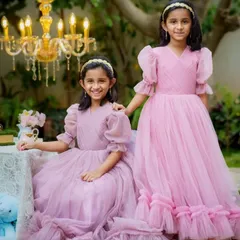 Two sisters look lovely in matching dusty rose gowns made from soft tulle. I designed these with individual touches, like puffed sleeves and ruffled hems, to suit each girl's style for this outdoor party photoshoot.
