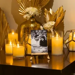 Another detail from the home Roka. A cherished photo of the couple is highlighted by golden decor elements and an array of candles in geometric holders, adding a touch of modern elegance.