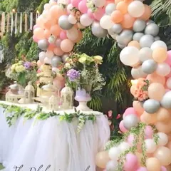 A dreamy boho-chic dessert table framed by a pastel balloon arch. The tulle table skirt and soft colors created a whimsical and gentle atmosphere for the celebration.