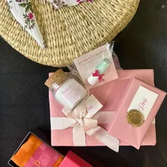A peek at the personalized items inside the bridesmaid hamper, including a custom-wrapped gift, a jar of bath salts, and a monogrammed box.