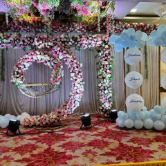 We create grand and memorable naming ceremony decorations for large venues. This stage features a magnificent floral arch and a crescent-shaped floral cradle holder, combining traditional elements with modern aesthetics. The personalized balloon display adds a unique touch for the baby.