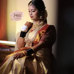A moment of quiet elegance before the ceremony. This bride's Muhurtham look features soft, glowing makeup and traditional jewellery, perfectly complementing her gold and red silk saree.