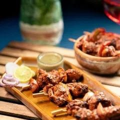 A platter of Murg Adani Boti served with fresh lemon, onions, and a side of mint chutney. This is a classic appetizer that I prepare with the freshest chicken.