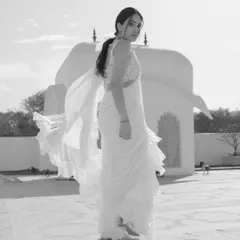 A dynamic black and white shot of Sandy, her ruffled saree catching the wind, creating a sense of movement and freedom.