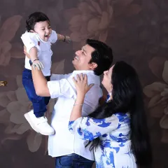 A joyful family moment, with dad lifting their baby high in the air. This candid shot captures the love and laughter shared between parents and their child.
