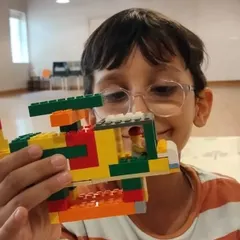 A student proudly displays the helicopter he built, a project that combines creative design with mechanical principles.