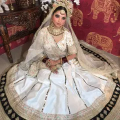 Two shots of a model in a white lehenga, showcasing a beautiful gold and kundan choker set. The jewellery provides a traditional contrast to the modern lehenga.