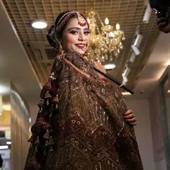 Our beautiful bride is all smiles, ready for her big day. This shot captures her complete look, from the detailed makeup to the traditional jewelry and dupatta setting.