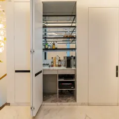 The magic revealed. The seamless wall panels open to unveil a fully stocked mini-bar with a coffee machine, perfect for entertaining during movie breaks. This is smart, hidden functionality at its best.