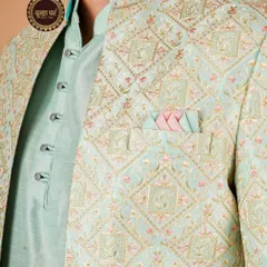 Pastel perfection for the modern groom. This close-up reveals the delicate and intricate embroidery on a mint green and pink jacket, a true work of art.
