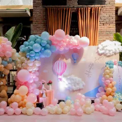 A full view of the 'Up, Up & Away' hot air balloon themed baby shower. The pastel balloon clouds and backdrop created a soft, dreamy atmosphere.