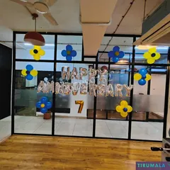 Celebrating a 7th company anniversary with 'Happy Anniversary' foil balloons and simple balloon clusters in the office common area.