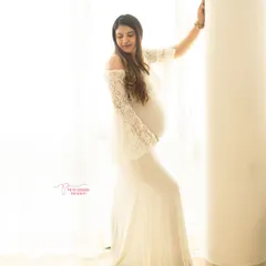 Ethereal and serene. This portrait uses soft, natural window light and a delicate white lace gown to create a timeless and angelic image of the mother-to-be.