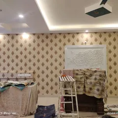 A living room wall covered in a traditional beige and brown damask wallpaper. This project shows how wallpaper can add warmth and character to a large space.
