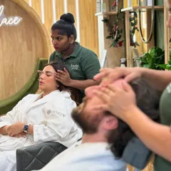 A couple enjoying a relaxing head massage side-by-side. This treatment is not only deeply calming but also helps improve circulation and promotes a healthy scalp.
