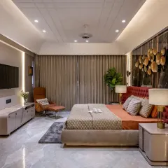 A wider view of the bedroom from ID 8, this shot showcases the full layout, including the TV unit with fluted paneling and a comfortable lounge chair. The design balances bold statements with serene, functional elements.