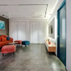 A wide shot of the T7 T8 living room, showing the balance between the bold sofa, the sleek media unit, and the soft light from the large windows.