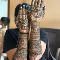 A classic full-arm bridal mehendi design, perfect for an engagement or wedding. Notice the fine line work, the balance between the intricate jaal (net) patterns on the palm and the bold floral bands on the forearm, creating a rich and complete look.