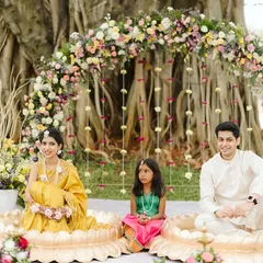 A beautiful family moment during the Haldi ceremony. The decor was designed to be a picturesque frame, with the couple seated in brass lotus urlis under a stunning pastel floral arch.
