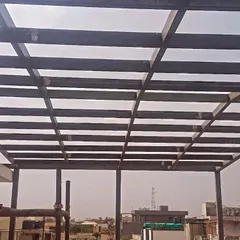 A view from below the steel pergola framework on a rooftop project. This grid structure is lightweight yet strong, forming the basis for a covered outdoor area that adds valuable living space to the home.