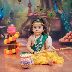 A serene portrait of a baby Krishna, holding his flute against a backdrop of peacocks. I focus on creating a calm environment to capture these peaceful moments.