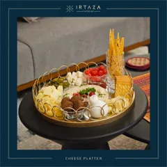 A stylish and modern cheese platter served on a gold-rimmed tray, showcasing a variety of textures and flavors from creamy hummus to crunchy breadsticks.
